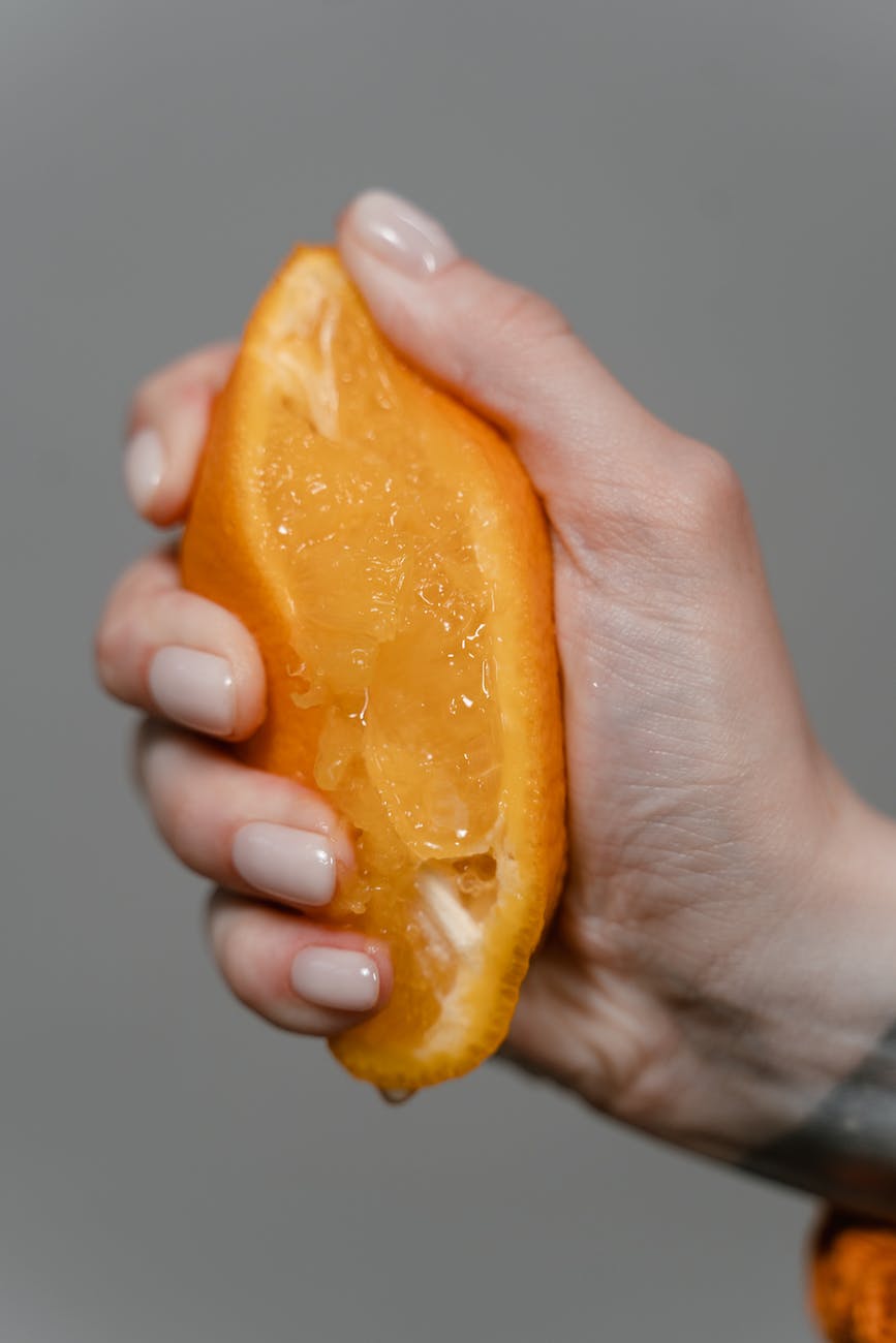 person squeezing an orange