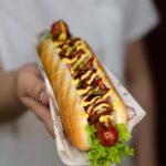 woman holding an american hot dog